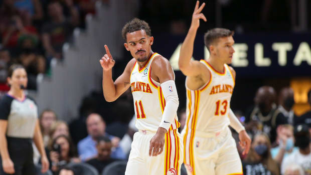 Trae Young and Bogdan Bogdanovic point to the sky after a made shot.